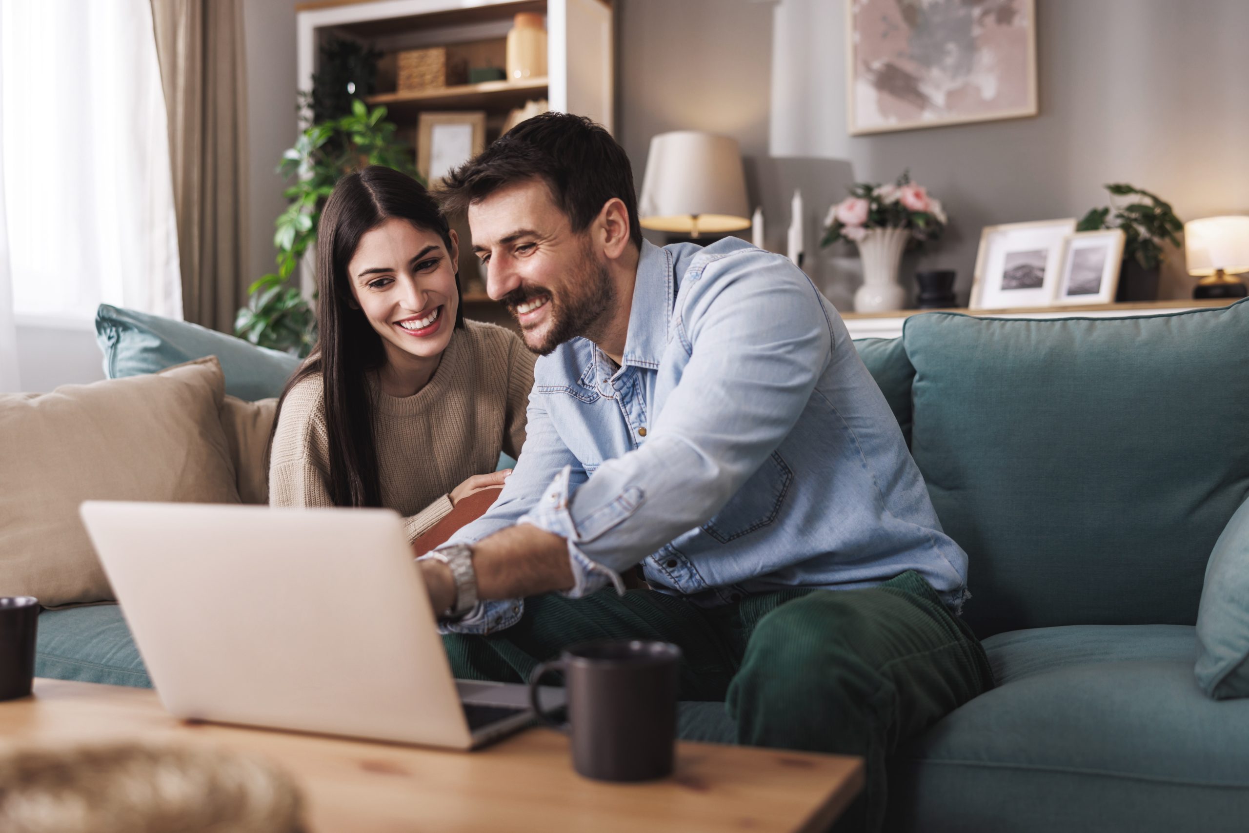Couple de particulier heureux en consultant leur suivi de gestion de patrimoine sur un ordinateur